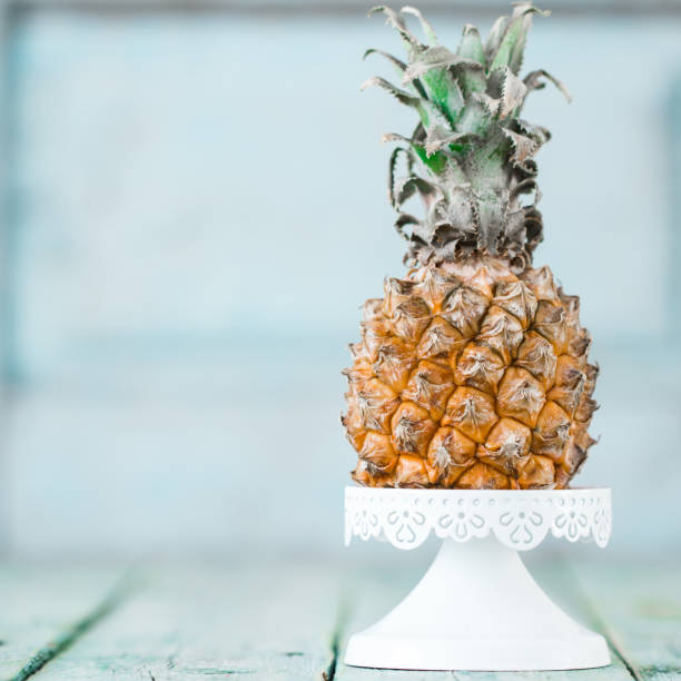 Ripe baby pineapple on a wooden background, tropical fruits