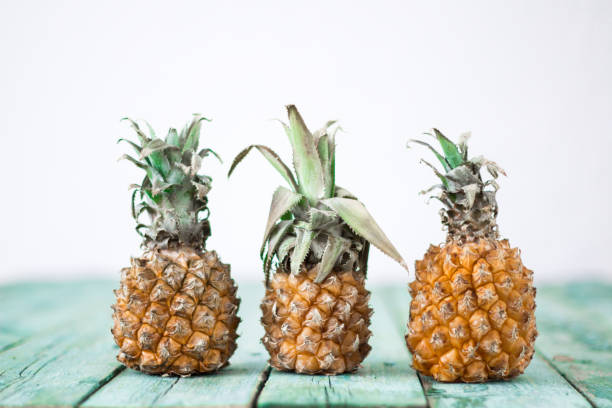 Ripe baby pineapple on a wooden background, tropical fruits