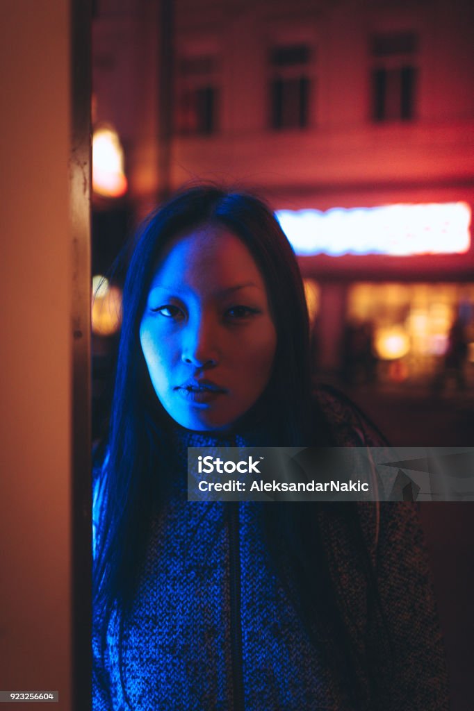 Under the neon lights Portrait of a young woman illuminated by neon city lights Fashion Model Stock Photo