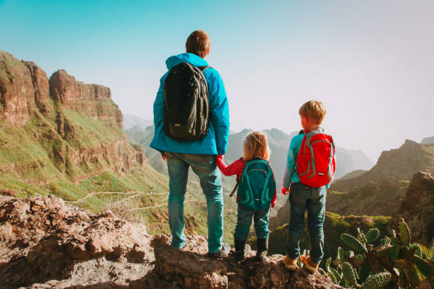 istock father and two kids hiking climbing in mountains 923259662