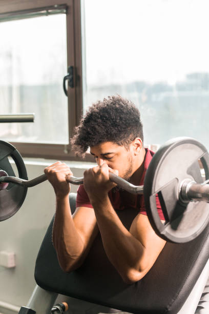 istock Young men lifting weights in gym 923263572