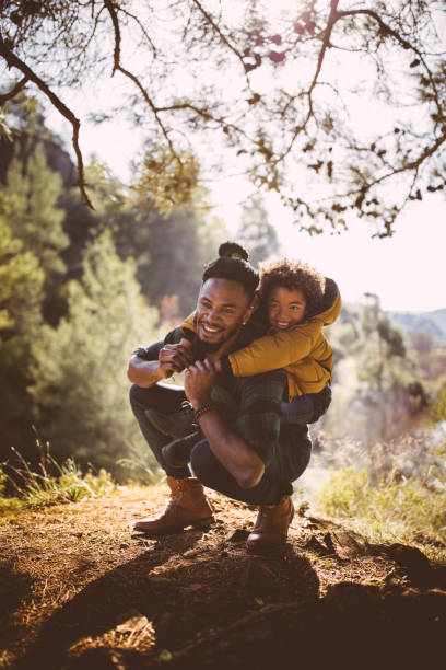 istock Father and son having fun with piggyback under forest tree 923267720