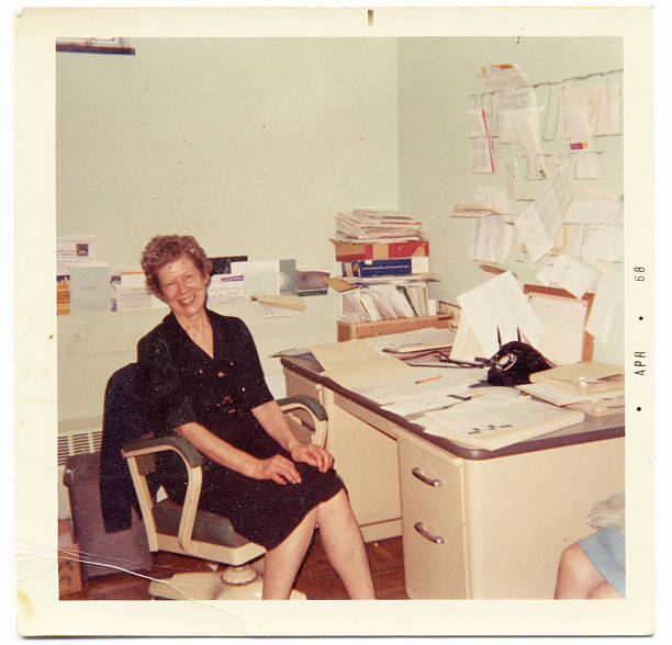 Vintage photograph of an happy secretary sitting at her desk stock photo