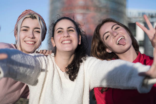 istock Three happy best girlfriends outdoors making selfie on smartphone. 923298000