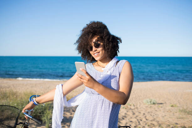 istock Woman with bike having fun on beach 923315650