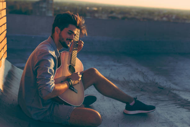 istock Guy playing the guitar on a building rooftop 923318476