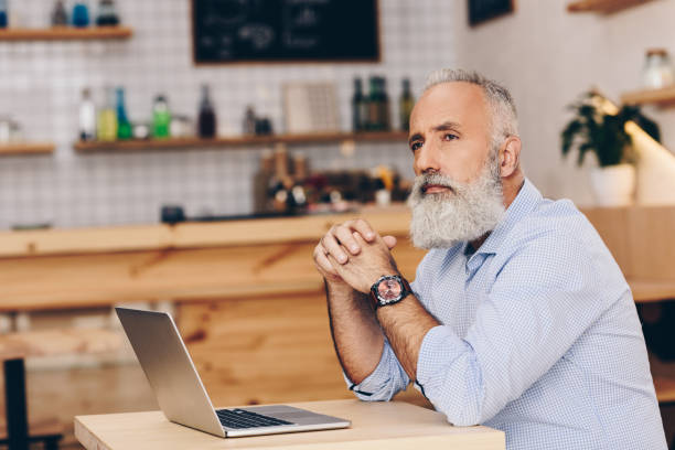 istock senior man with laptop in cafe 923318596