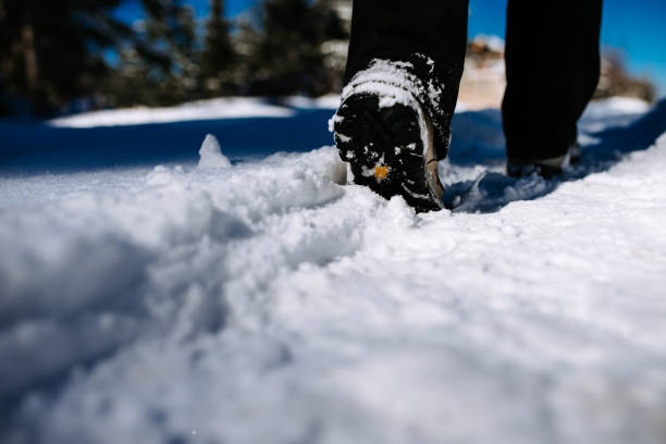 Close-up image of hiker walking on mountain covered with snow.