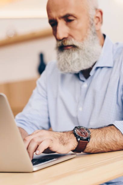 istock senior man with laptop in cafe 923334082