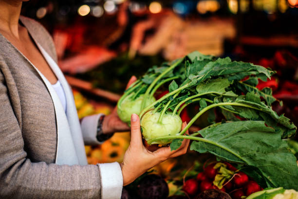 nahaufnahme bild einer frau mit kohlrabi am markt. - kohlrabi on food ripe stock-fotos und bilder