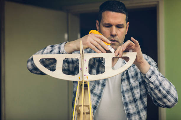 RC Airplane Hobby Mature man assembling parts of airplane in his workshop. toy airplane stock pictures, royalty-free photos & images