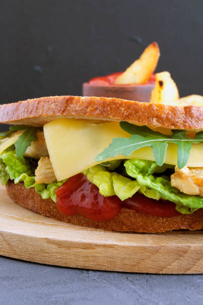 istock Sandwich and fried potatoes on a wooden Board. 923341474