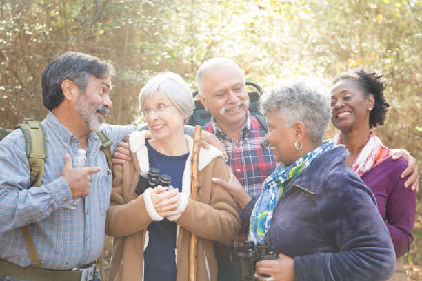 multi-ethnic, active senior adult friends hiking in wooded forest area. - indiana autumn woods forest imagens e fotografias de stock