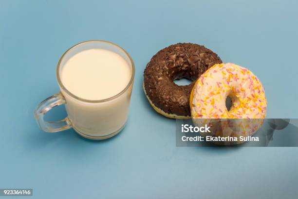 Glasierte Donuts Und Milch In Eine Glasschale Auf Blauem Hintergrund Stockfoto und mehr Bilder von Blau