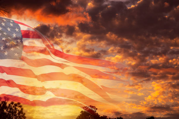 istock USA flag overlay on dramatic sunset sky. 923369374