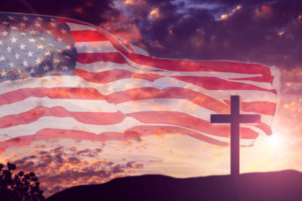 USA flag overlay on dramatic purple sunset sky with one Christianity cross standing on a hill for Good Friday, Easter holidays.