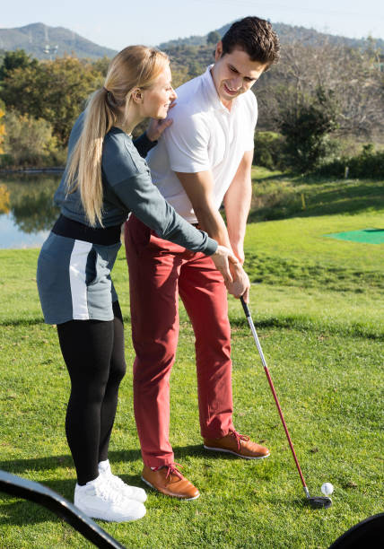 istock Pretty trainer showing player how to hit ball 923375282