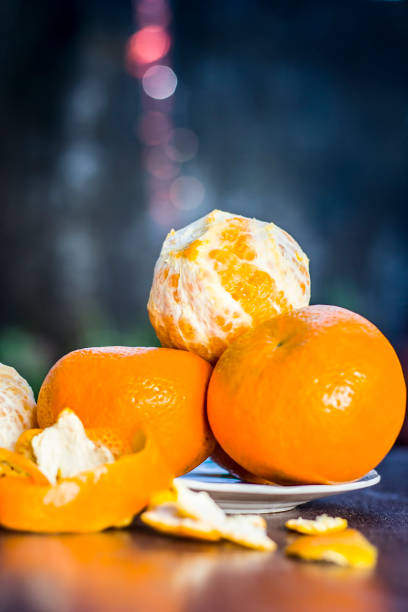 Close up of fresh ripe oranges,Citrus aurantium in a plate on wooden surface. stock photo