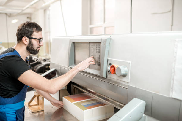 istock Man working with cutting machine at the printing plant 923383410