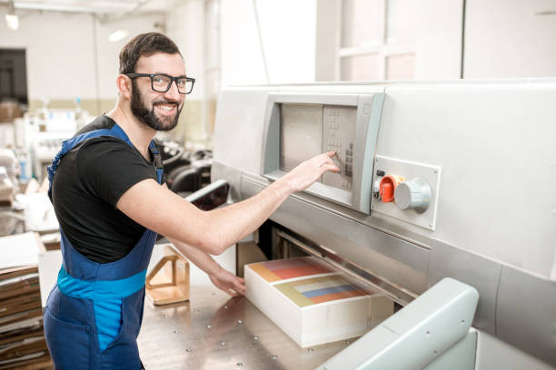 istock Man working with cutting machine at the printing plant 923383434