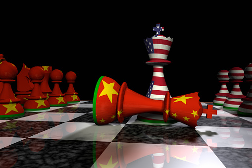 Render of a chessboard with pieces decorated with the USA and Chinese flags. A king has advanced from both sides and the king from the Chinese side has resigned.