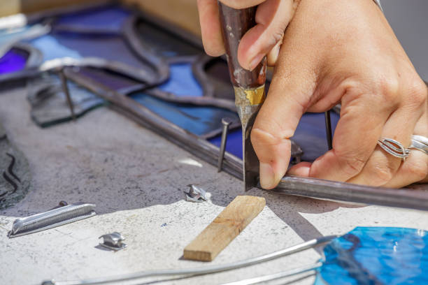 istock Closeup of woman's hand doing stained glass work with tools. 923394316