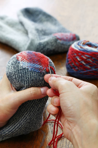 istock darning socks, repairing holes in socks 923405734