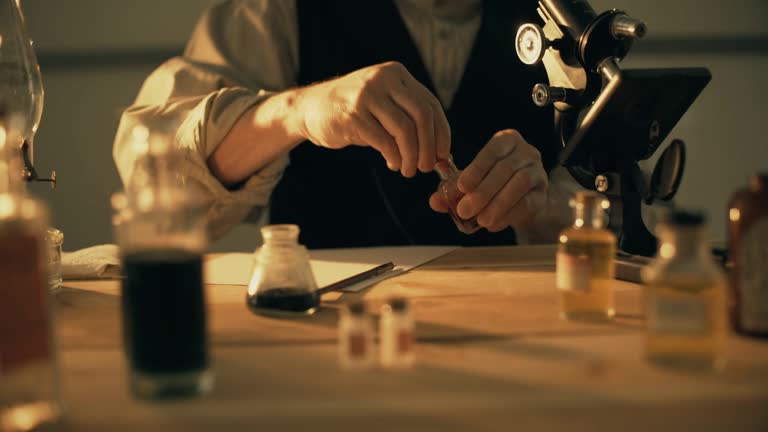 turn of the century scientist using a microscope