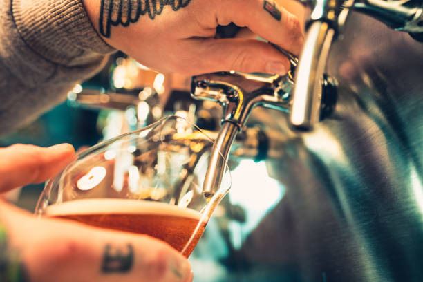 istock Hand of bartender pouring a large lager beer in tap 923410170