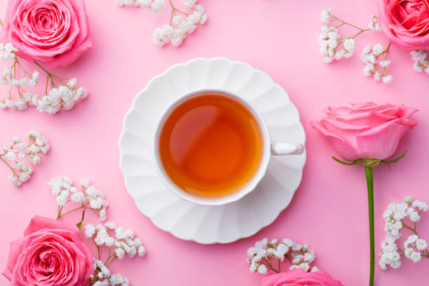 istock Cup of tea with fresh flowers on pink background. Top view. Copy space 923413616