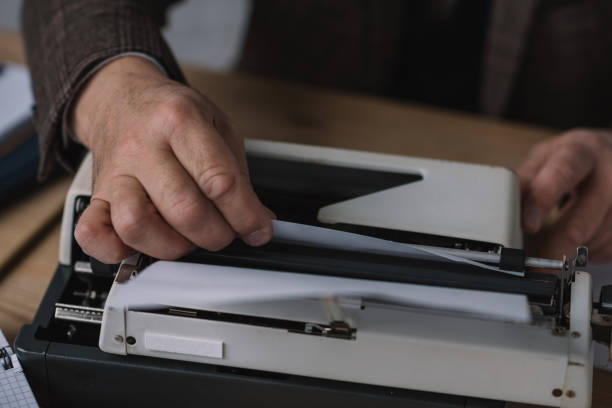 istock cropped shot of writer loading paper into typewriter 923413840