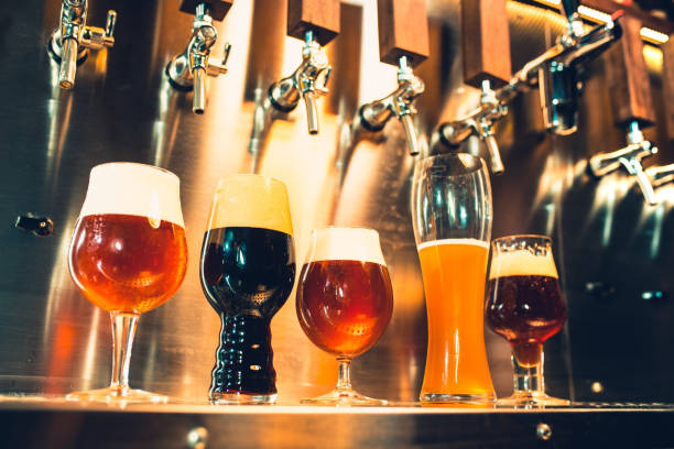 grifos de cerveza en un bar - cerveza lager fotografías e imágenes de stock