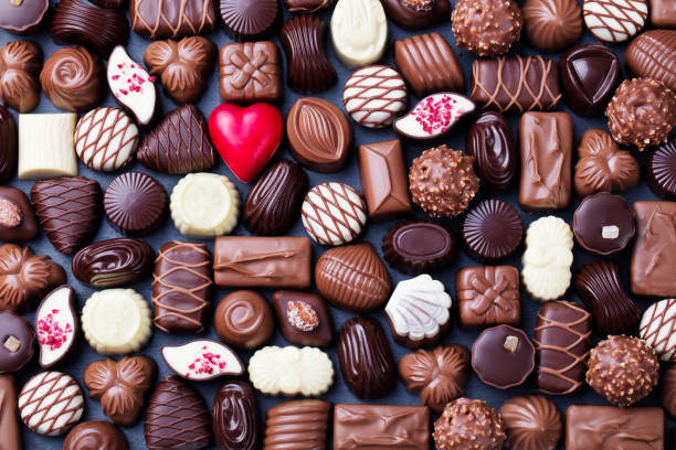 assortiment de bonbons de chocolat fins, blanc, noir et chocolat au lait fond de bonbons. copiez l’espace. vue de dessus. - chocolat photos et images de collection