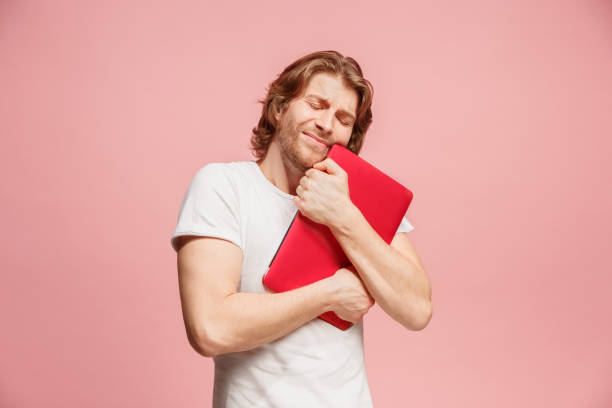 istock Businessman hugging laptop on pink 923433412