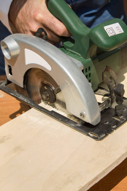 istock The carpenter cuts the board with a manual electric saw. Construction worker crosses a board with a circular saw. 923435648