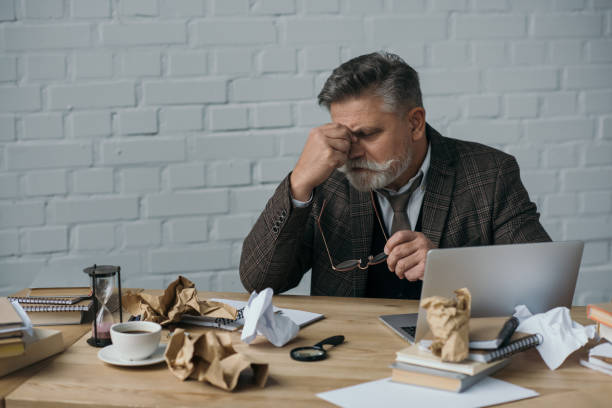 istock overworked senior writer sitting at messy workplace 923438608