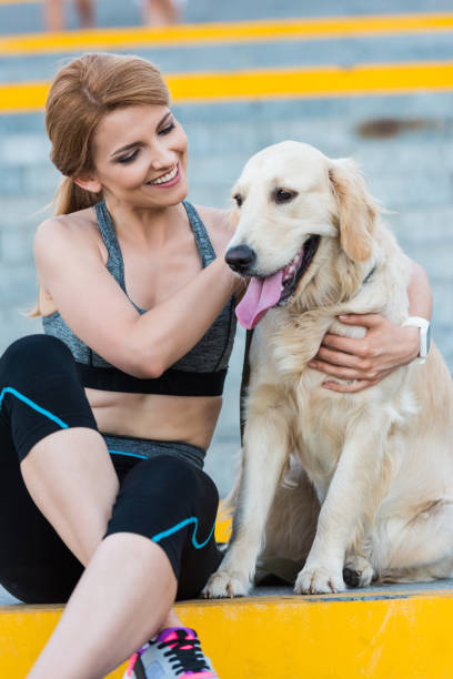 istock sportswoman sitting with dog 923444244