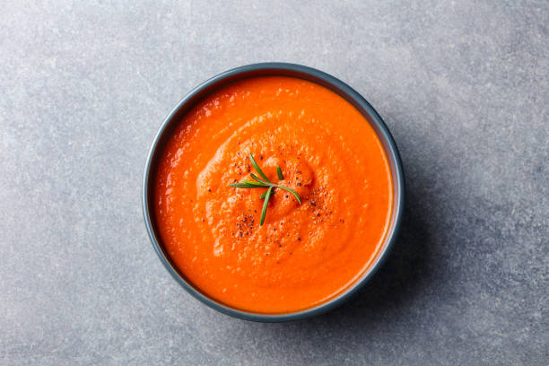 tomatensuppe in einer schwarzen schüssel auf grauem steinhintergrund. ansicht von oben. kopieren sie den speicherplatz. - curry sauces stock-fotos und bilder