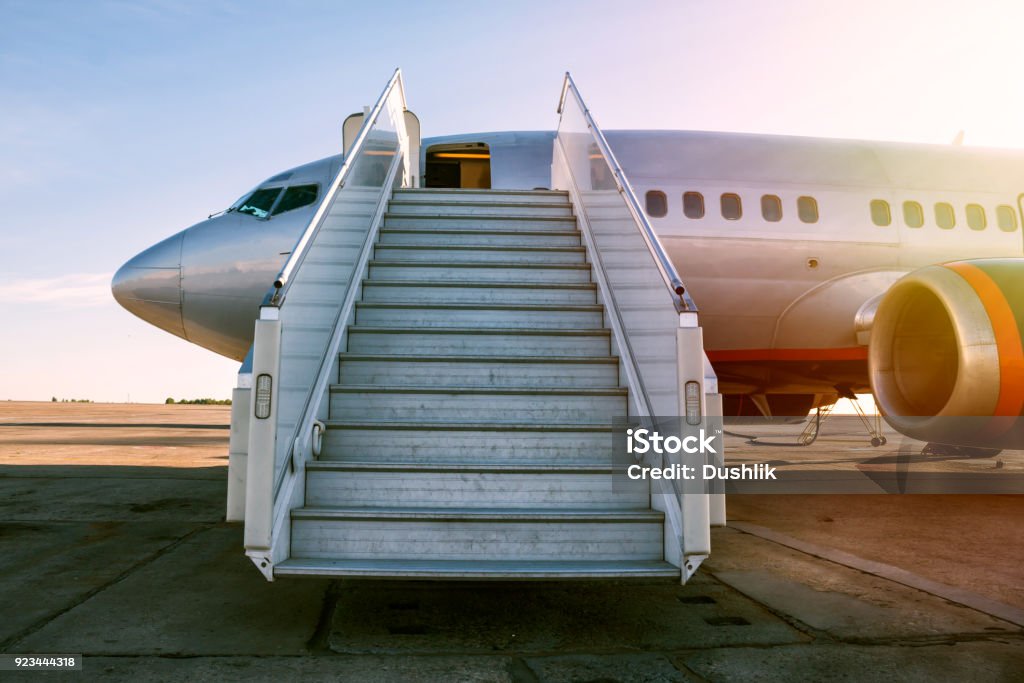 Passenger airplane with a boarding steps in the morning sun Airplane Stock Photo