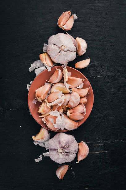 istock Garlic on a plate. Fresh garlic on a wooden background. Top view. Copy space. 923444612