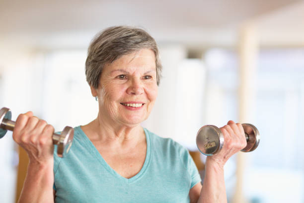 istock senior woman lifting weights in gym 923448234