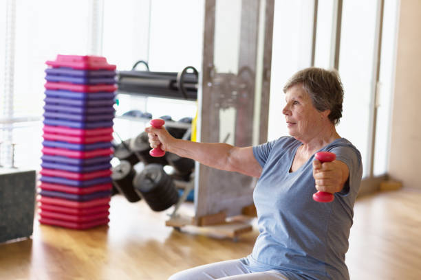 istock senior woman lifting weights in gym 923448294