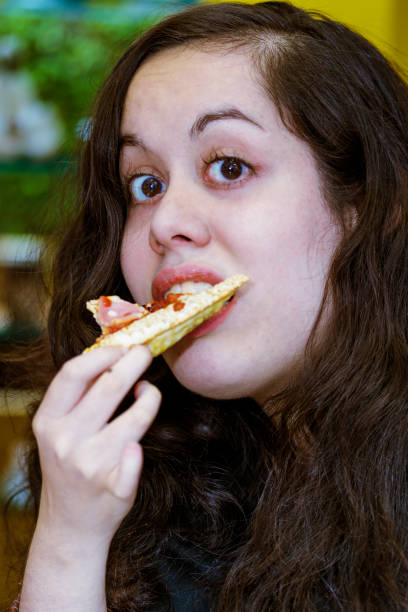 istock Young woman eating pizza 923451400