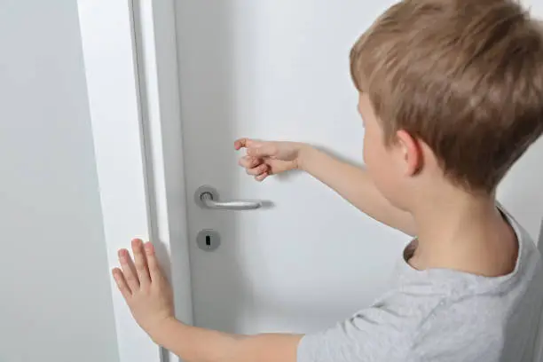 Child knocking on door before entering, home privacy concept