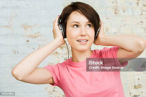 Young Woman Wearing Headphones Stock Photo - Download Image Now - Adult, Adults Only, Brick Wall