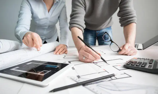 Photo of Designers discuss the sketches inside the house.