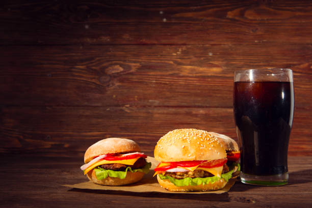 istock Two BBQ hamburgers with cola on wooden background. 923488156