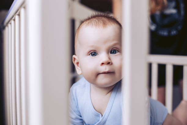 istock A child in a crib marvels at what is happening 923488218