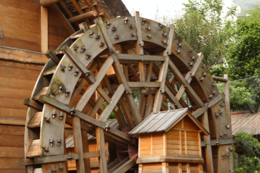 Enterprise, Mississippi, United States – April 30, 2018: A water wheel and historic building stand beside the waterfall at Dunn's Fall Water Park in Mississippi