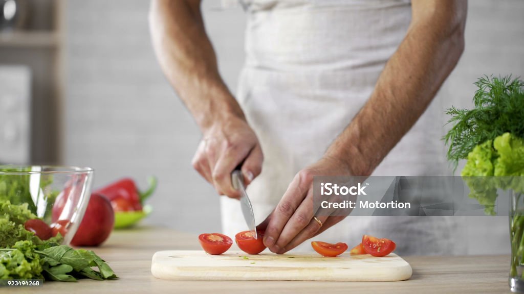 Gewicht-Verlust-männlichen Chef schneiden Tomaten zum Salat aus frischem Gemüse nach Hause, auf Tisch - Lizenzfrei Abnehmen Stock-Foto